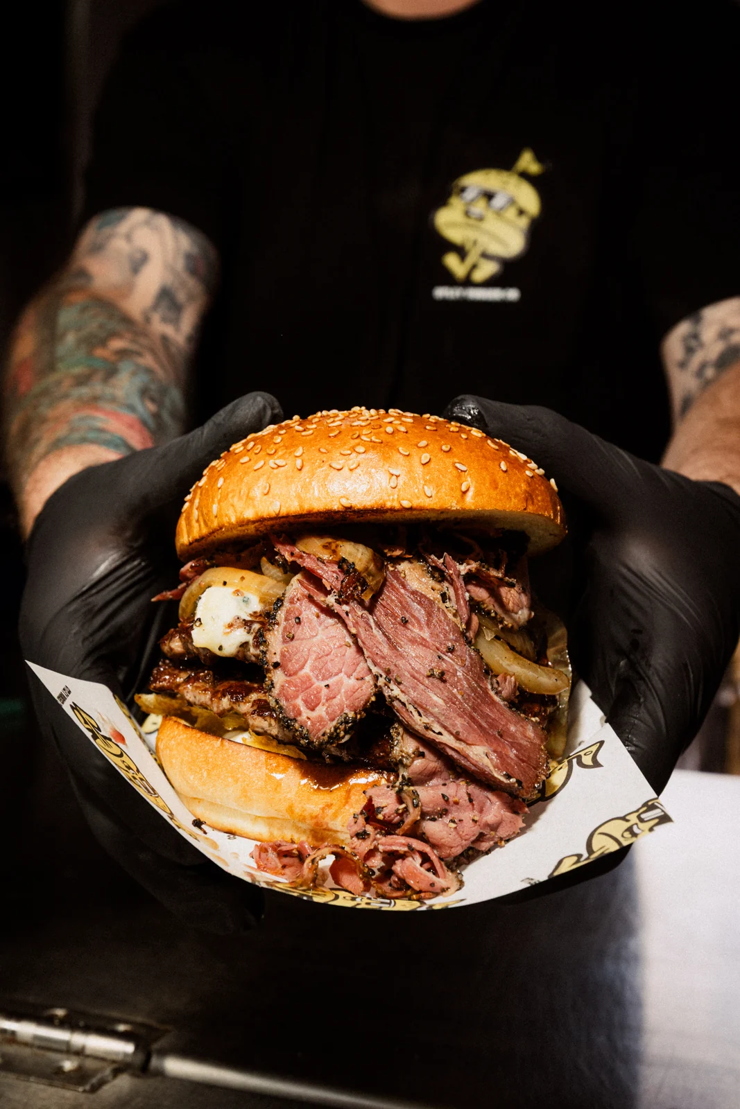 A burger held towards the camera at Otley Burger
